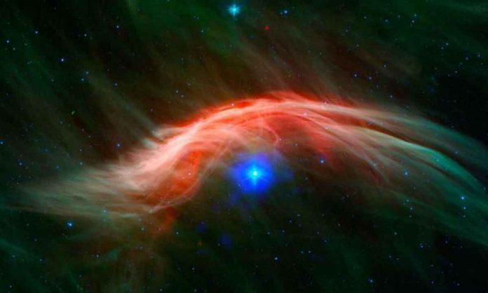 A fast-moving star is colliding with interstellar gas, creating a spectacular bow shock